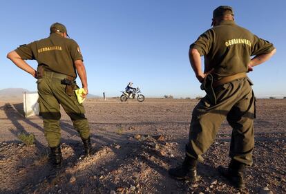 Dos agentes de la Policia argentina observan el paso del piloto francés Cyril Despres.