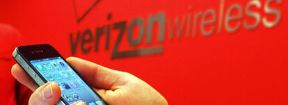 Un empleado de Verizon sostiene un iPhone. 