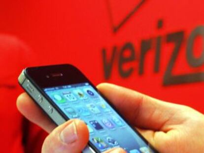 Un empleado de Verizon sostiene un iPhone. 