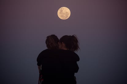 Una pareja se abraza debajo de la luna, en Florianópolis, Brasil.