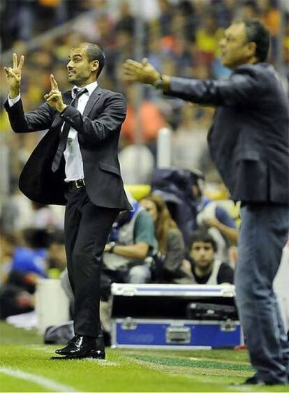 Pep Guardiola, al fondo, junto a Joaquín Caparrós, en el partido de ida de la Supercopa de España.