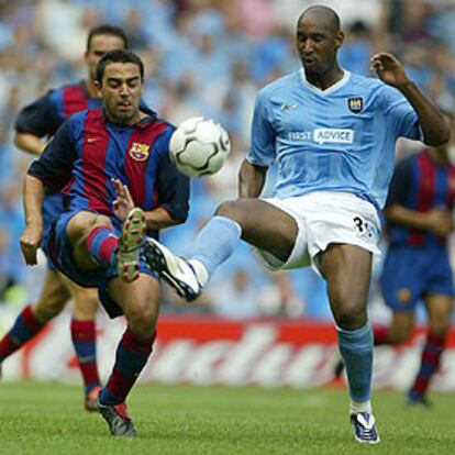 Xavi y Anelka pugnan por el balón.