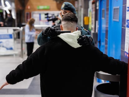 Un agente de la Guardia Civil cacheaba en febrero de 2022 a un joven en un control para prevenir la violencia entre bandas, en la estación de metro de Arganda del Rey (Madrid).