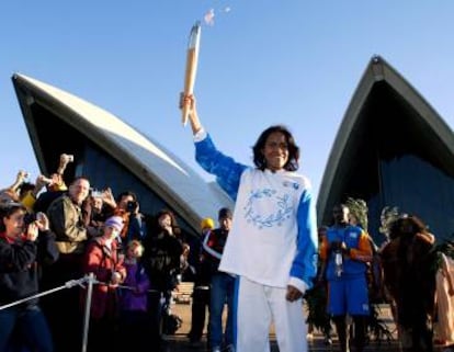 Cathy Freeman com a tocha olímpica diante da Ópera de Sydney .