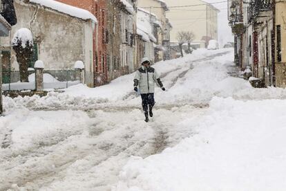 Un hombre camina por una de las calles de la localidad turolense de Bronchales que se encuentra cubierta de nieve. Un total de 139 alumnos de centros educativos de la provincia de Teruel se han visto afectados por la nieve caída en las últimas horas, que ha provocado la suspensión de seis rutas escolares y afecciones parciales a otras tres.