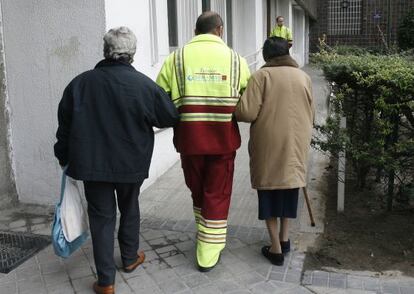 Un asistente acompa&ntilde;a a dos pacientes de di&aacute;lisis en Madrid.