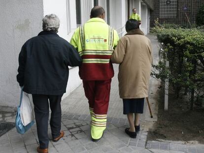 Un asistente acompa&ntilde;a a dos pacientes de di&aacute;lisis en Madrid.