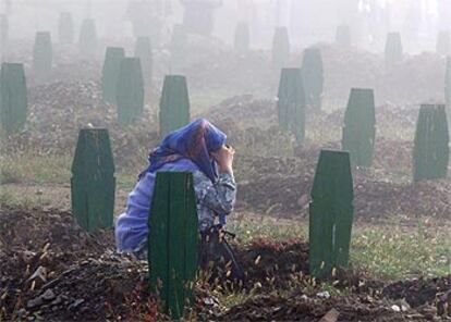 Una musulmana reza ante una tumba en el cementerio de Srebrenica, en septiembre de 2003.