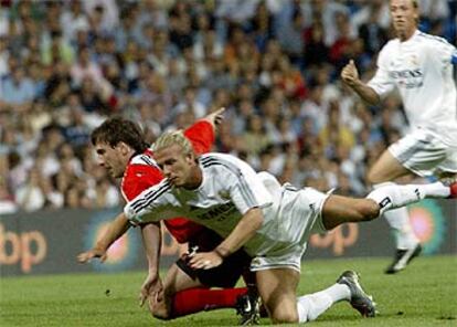 Beckham pelea con Tuzzio por el balón durante el partido del martes entre el Madrid y el River Plate.