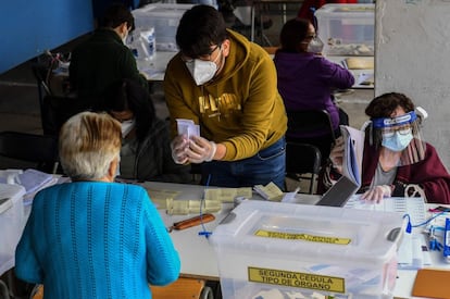 Chile, que el sábado superó el medio millón de infectados por covid-19 y alcanzó los 13.892 muertos desde el inicio de la pandemia en marzo, es el decimocuarto país del mundo con más casos, según la Universidad Johns Hopkins. En la imagen, una mujer es ayudada para votar en Santiago de Chile.