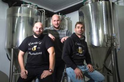 Los tres emprendedores junto a los depósitos de cerveza.