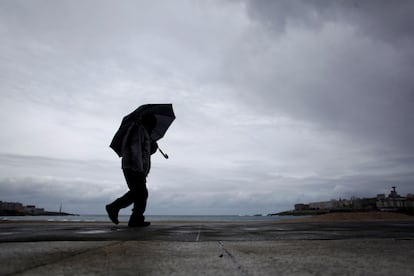 Un hombre camina por el paseo marítimo de A Coruña.