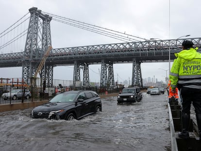 A police officer from the NYPD Highway Patrol looks as motorists drive through a flooded street after heavy rains in New York City, September 29, 2023.