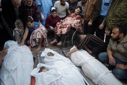 Familiares y amigos junto a los cadáveres de varios palestinos muertos en los ataques israelíes, este lunes en la morgue del hospital Nasser en Jan Yunis. 