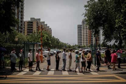 Personal sanitario hace pruebas a los residentes en Pekín, este jueves, tras el brote de coronavirus en su principal centro mayorista de alimentación. EFE/ Stringer