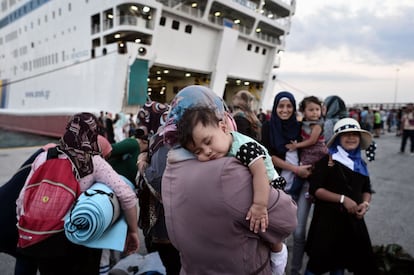 A la imatge, una dona porta el seu fill a coll mentre intenta embarcar al port del Pireu en un ferri llogat pel Govern grec. El vaixell va transportar 2.000 immigrants des de l'illa de Lesbos a la zona continental de Grècia. Des d'aquest lloc, els refugiats miren d'arribar a d'altres països d'Europa, a través de Macedònia, Sèrbia i Àustria.