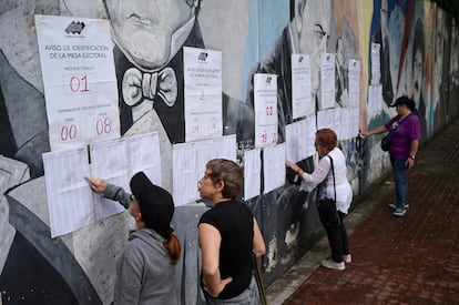 Un grupo de mujeres busca su nombre en las listas electorales.