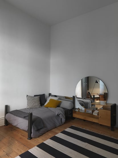 La cama del dormitorio es un diseño de los años cincuenta del arquitecto italiano Luigi Caccia Dominioni. El aparador bajo, con espejo circular, es un mueble de los años cincuenta. Los cojines y la ropa de cama son de Society. La lámpara es un diseño de Paolo Rizzatto producido por la empresa Flos. Y la alfombra a rayas es de la empresa Affari.