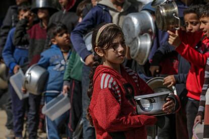 Palestinos desplazados por la guerra hacen cola para conseguir comida este sábado en Deir Al Balah, en el sur de Gaza.