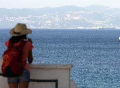 Una turista observa las aguas del Estrecho de Gibraltar donde se podría ubicar la ampliación del puerto de Tarifa, con África al fondo.