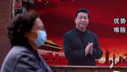 Una mujer pasa frente a un cartel con la imagen de Xi Jinping en Shanghái.
