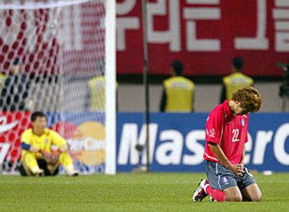 El coreano Song Chong, de rodillas, y el portero Lee Woon, sentado en el suelo, muestran su desconsuelo por la derrota de su selección.