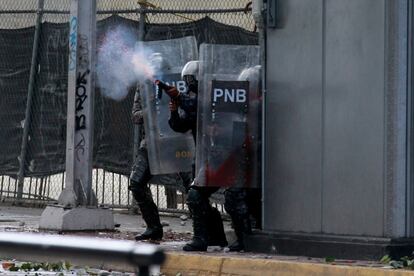 Miembros de la Policía Nacional Bolivariana se enfrentan a manifestantes durante una protesta contra el Gobierno del presidente de Venezuela, Nicolás Maduro, este miércoles en Caracas. El Gobierno chavista, que gobierna el país desde 1999, se ha enfrentado durante la madrugada de este jueves, y por tercer día consecutivo, a protestas de ciudadanos de barrios populares de Caracas, antes considerados bastiones del chavismo.