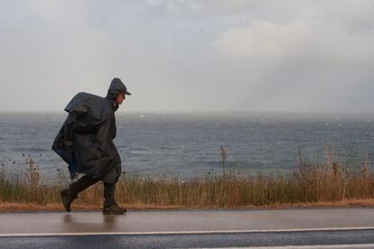 Peregrinos del Camino de la Costa, en Galicia, realizan la travesía cubiertos para ampararse de la lluvia y del frío, el 14 de octubre de 2018.
