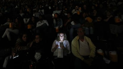 A young woman uses her cell phone during a film