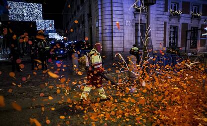 Los operarios limpian la Puerta del Sol tras las campanadas de Año Nuevo que concentraron a miles de personas.  