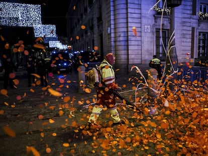 Los operarios limpian la Puerta del Sol tras las campanadas de Año Nuevo que concentraron a miles de personas.  