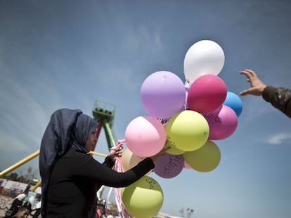 Jovem palestina carrega bal&otilde;es com frases que lembram o Dia Internacional da Mulher, nesta ter&ccedil;a-feira, em Gaza. 