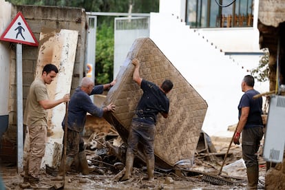 Vecinos sacan a la calle enseres dañados por las inundaciones en Benamargosa (Málaga), este jueves. 