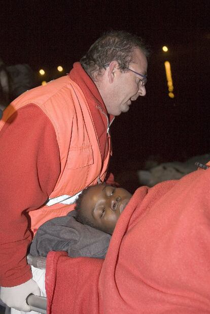 Un miembro de la Cruz Roja traslada a Judith, la mujer que ha dado a luz en una patera en la isla de Alborán, tras llegar al puerto de Motril.