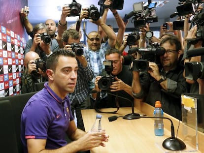 Xavi, rodeado de cámaras y fotógrafos, antes de iniciar su rueda de prensa. 