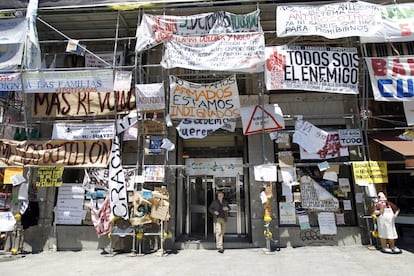 Carteles y pancartas cubren los andamios de uno de los edificios del El Corte Inglés. El ingenio de los indignados se despliega por los escaparates de los comercios de la Puerta del Sol y calles vecinas. Esto provoca los primeros problemas de convivencia con los comerciantes, que se quejan de que su presencia ha ocasionado un descenso de las ventas de entre el 50 y 80% y de que el perfil de los indignados de los primeros días ha derivado hacia uno más radical y menos dialogante. Los acampados aprueban en asamblea retirar los carteles de los pequeños comercios. La promesa de que la acampada terminará el próximo domingo calma a los comerciantes. En realidad se levantará el 12 junio, por decisión asamblearia, en la llamada Operación Patena, en la que los acampados recogen la plaza y mantienen un punto de información.