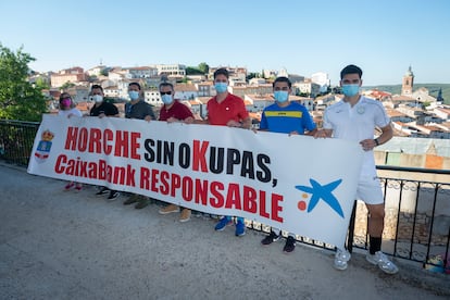 Varios vecinos de Horche posan con su pancarta contra los okupas del pueblo.