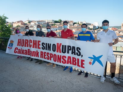 Varios vecinos de Horche posan con su pancarta contra los okupas del pueblo.