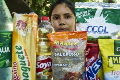 La situación empezó a deteriorarse cuando el modelo alimentario fue cambiando y pasó, en pocas décadas, de una alimentación basada en cultivos autóctonos, frutas, pescado, y agua fresca de los pozos o las fuentes que alimentan el río, a una alimentación exógena. En la foto, Joane posa junto a productos de alimentación envasados en plástico que su familia trae de la ciudad más cercana. 