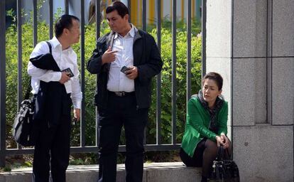 Guzaili Nuer, esposa de Ilham Tohti, descansa junto al abogado de su marido, este mi&eacute;rcoles frente al Tribunal Intermedio de Urumqi.