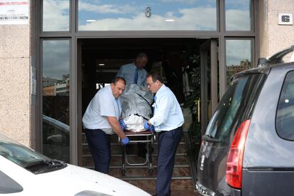 Trabajadores trasladan el cadáver de uno de los ancianos tras el incendio, este viernes. 