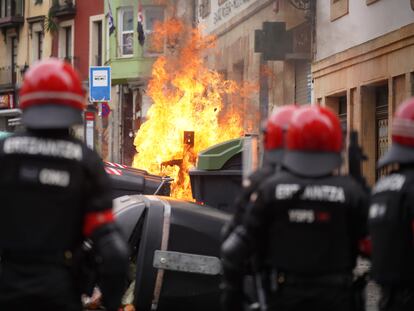 Agentes de la Ertzaintza observan la quema un contenedor durante los altercados producidos en una manifestación en febrero pasado en Bilbao.
