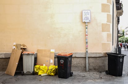 Basura fuera de los contenedores en una calle que desemboca en Tirso de Molina.