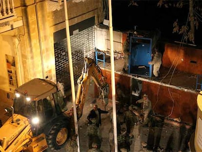 Soldados chipriotas desmontan el muro que divide Nicosia.