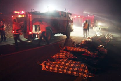 Los cuerpos de algunas de las víctimas yacen en la carretera.