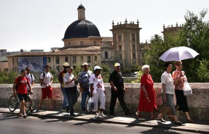 Un grupo de turistas cruza el puente de la Trinidad de Valencia, junto al Museo de Bellas Artes