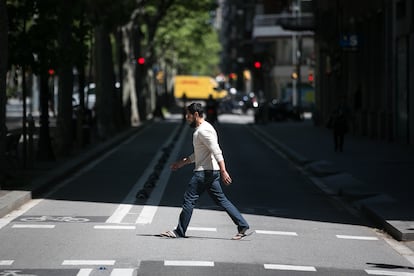 Un hombre cruza el carril lateral de la Gran Via de Barcelona, donde se cortará el tráfico para dar espacio a los peatones.