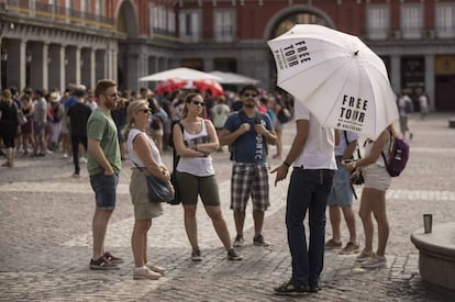 Un grupo de turistas escucha a un guía de un free tour en la plaza Mayor. 
 