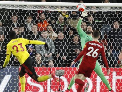 Alisson despeja el remate de cabeza de Sarr, en presencia de Robertson.