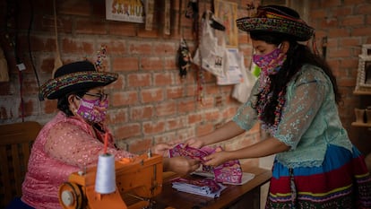 María Luisa Romaní de 51 años, confecciona las mascarillas en su antigua máquina de coser; su hija Milagros Ramos, de 24 años, las pinta.